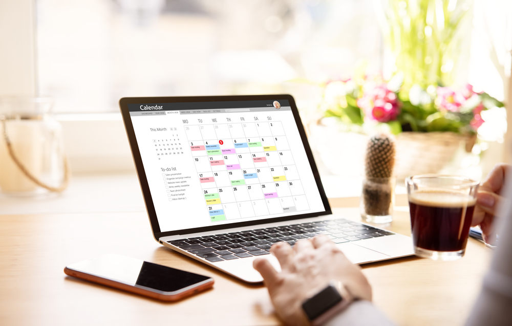 person's hands at computer with calendar open on the screen