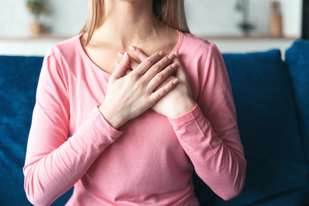 woman holding hands folded close to heart