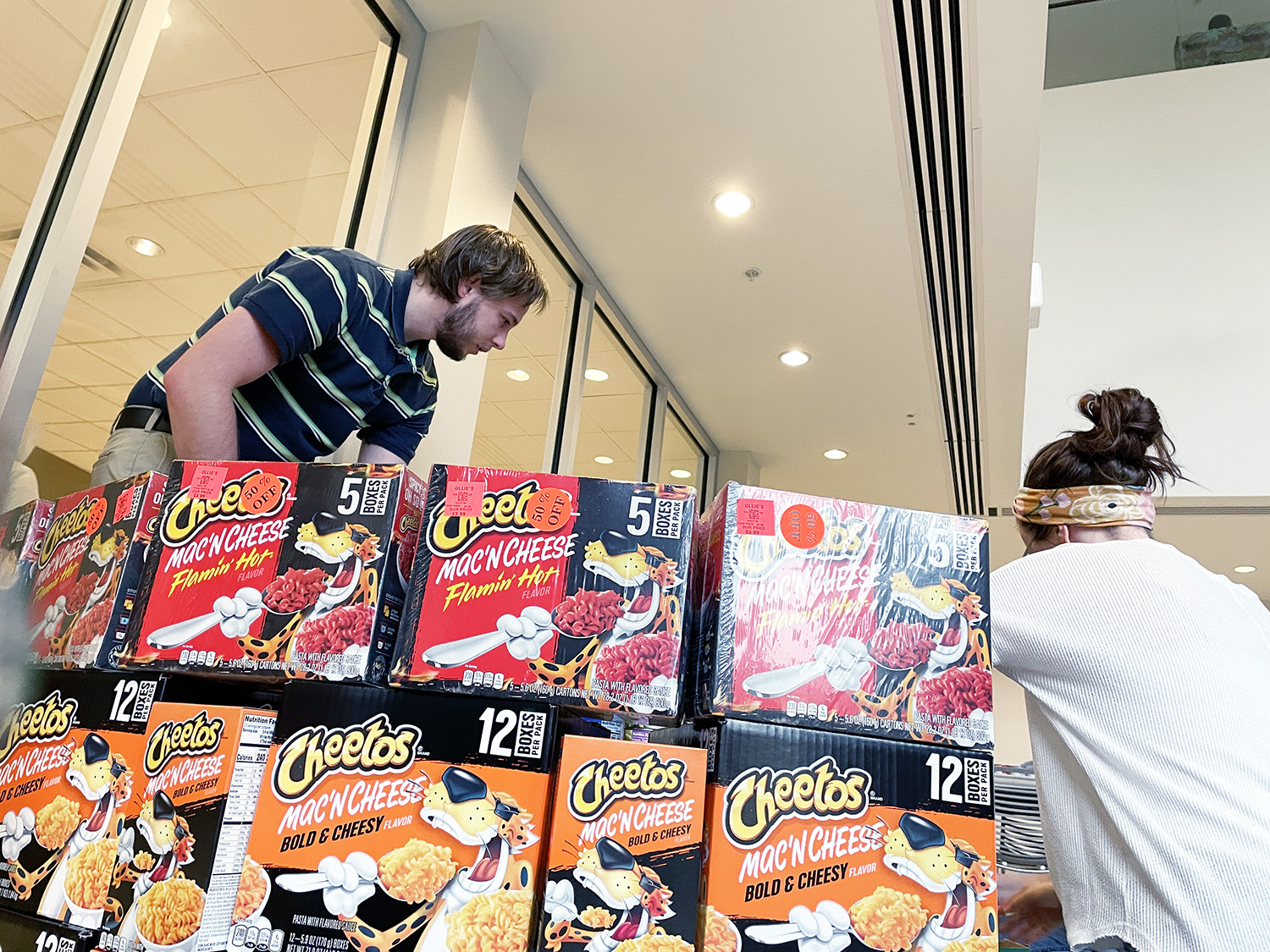 Two people building a sculpture with Cheetos Mac'n'Cheese