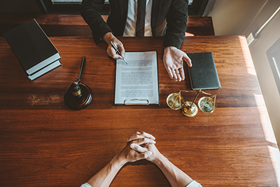 Two people at desk having discussion, only hands and arms showing