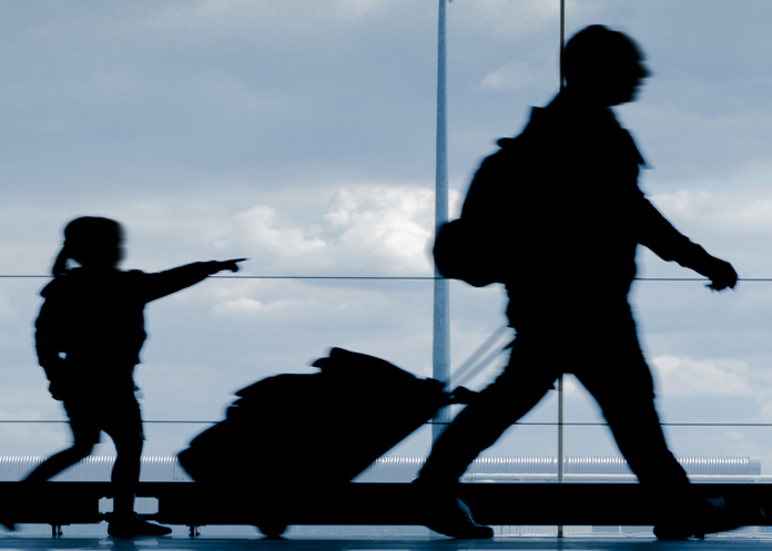 Silhouette of father and daughter walking at airport