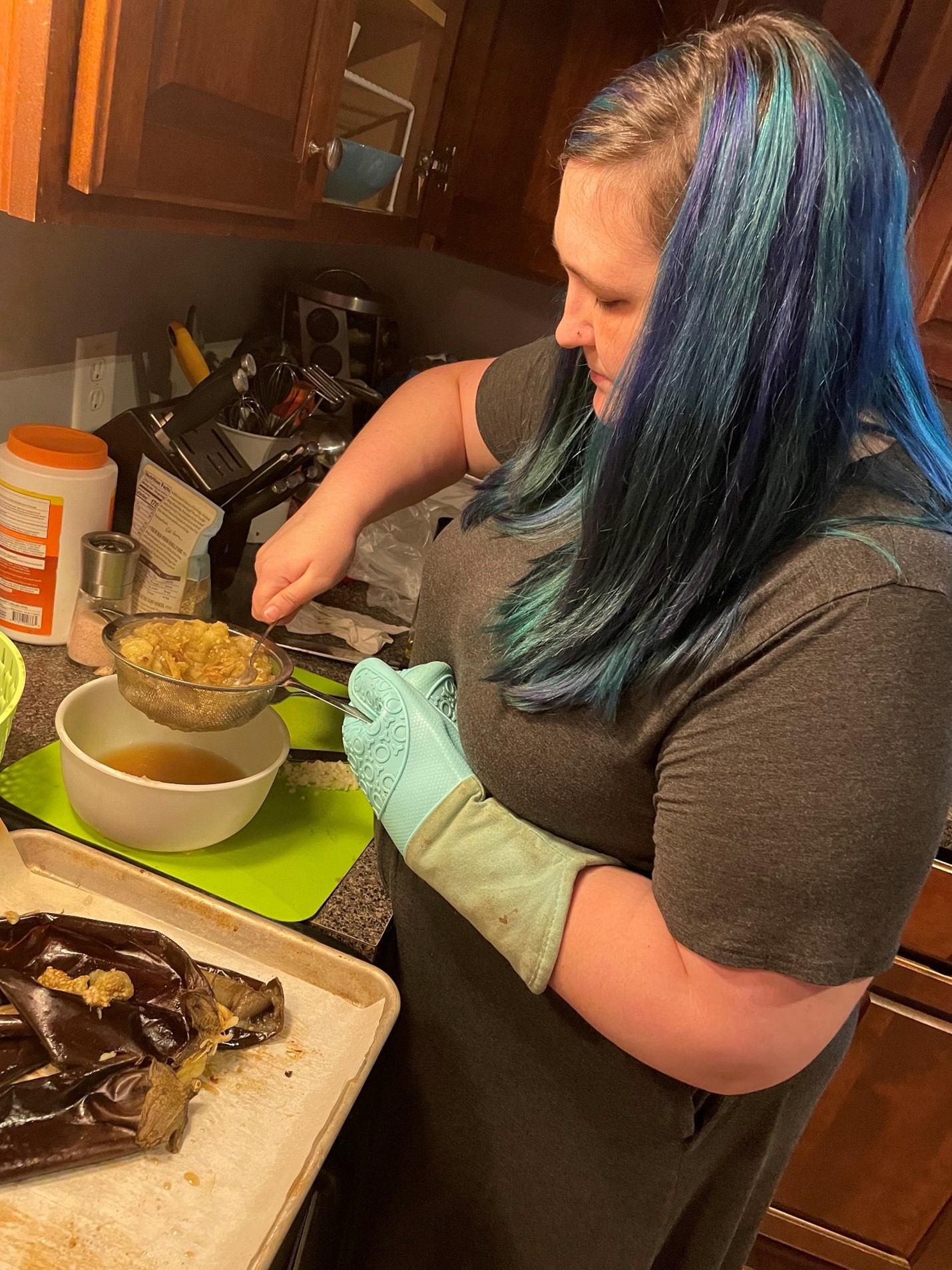 Meghan Cooper carefully straining ingredients for a dish.